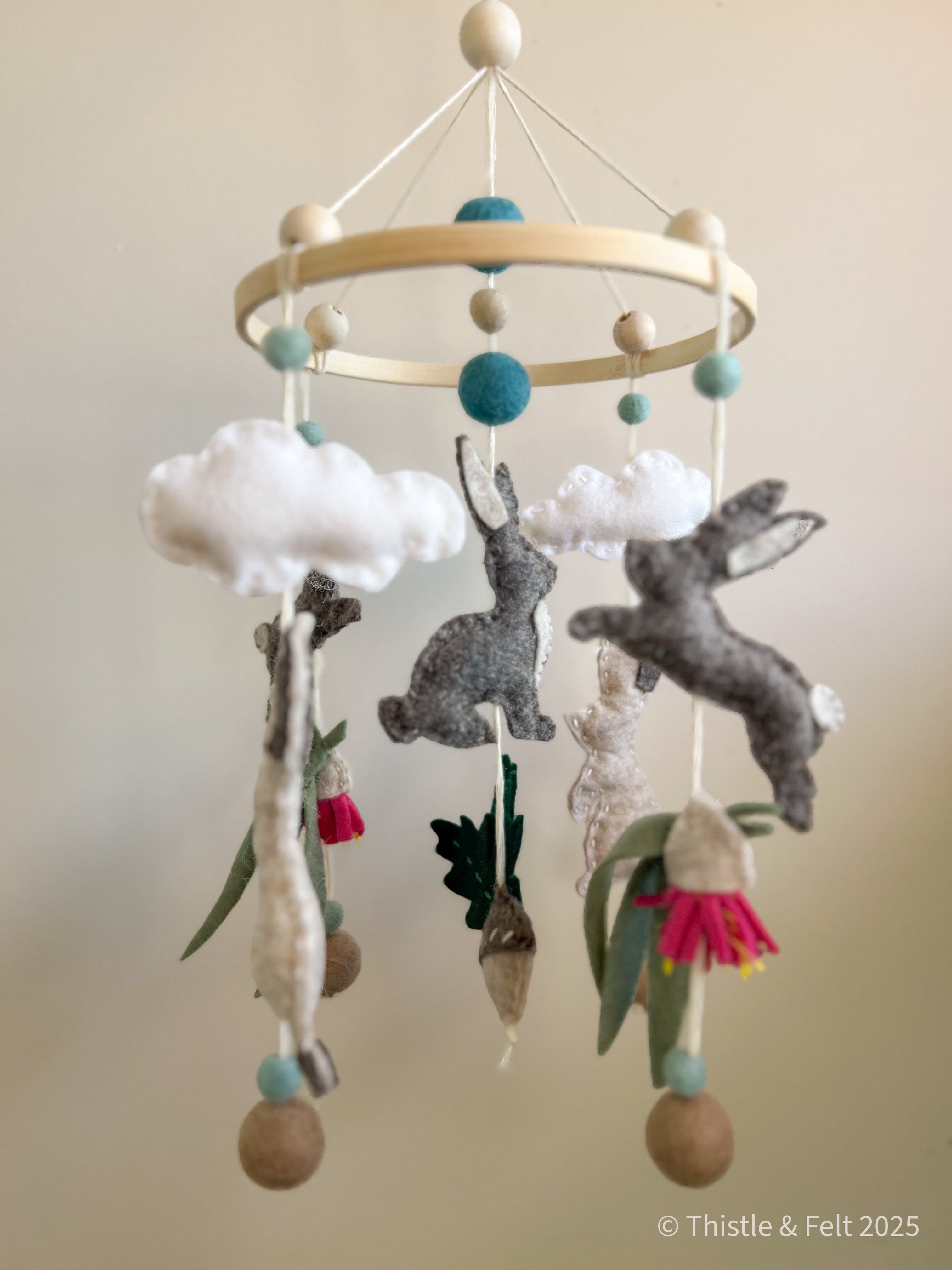 Handmade bunny felt nursery mobile with clouds by Thistle & Felt, perfect for natural nursery décor.