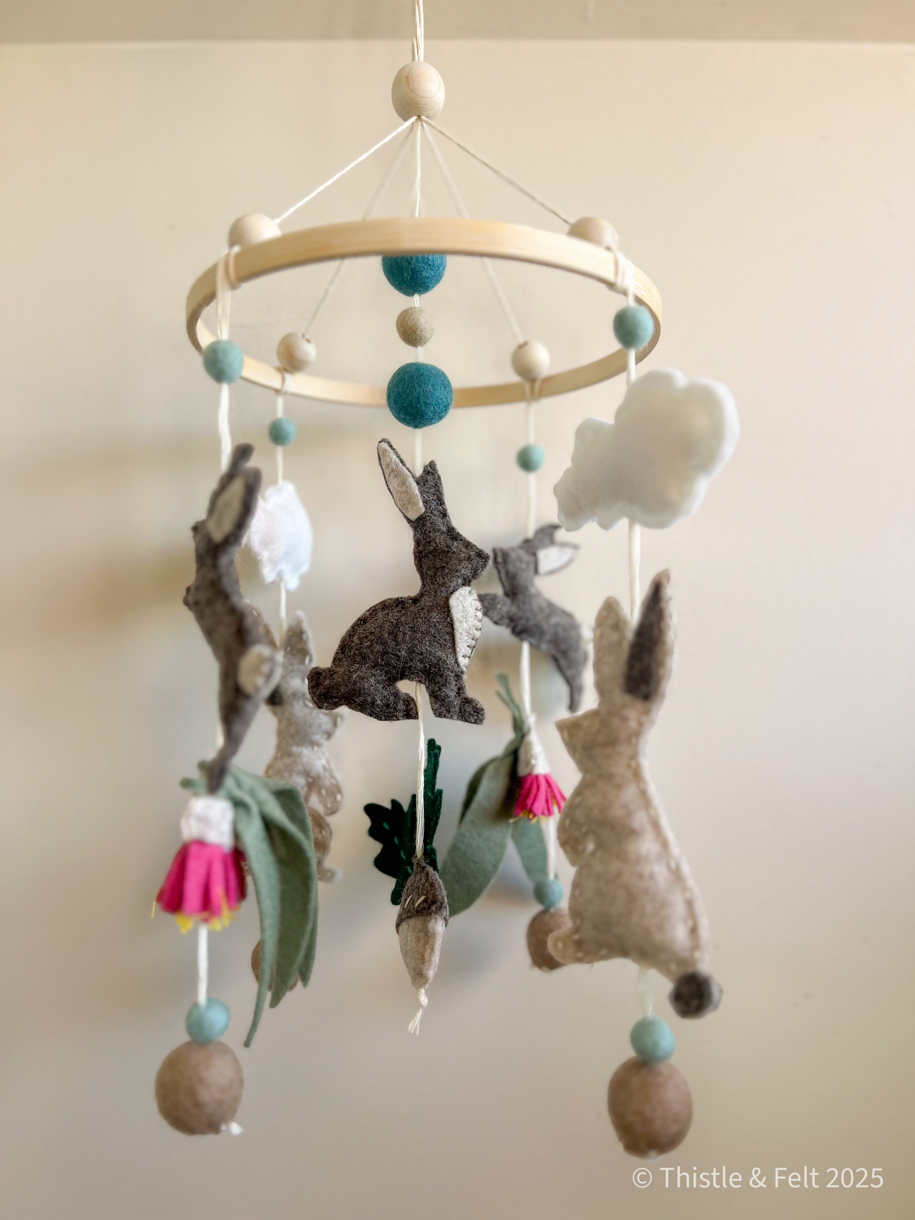 Handmade bunny felt nursery mobile with clouds by Thistle & Felt, perfect for natural nursery décor.