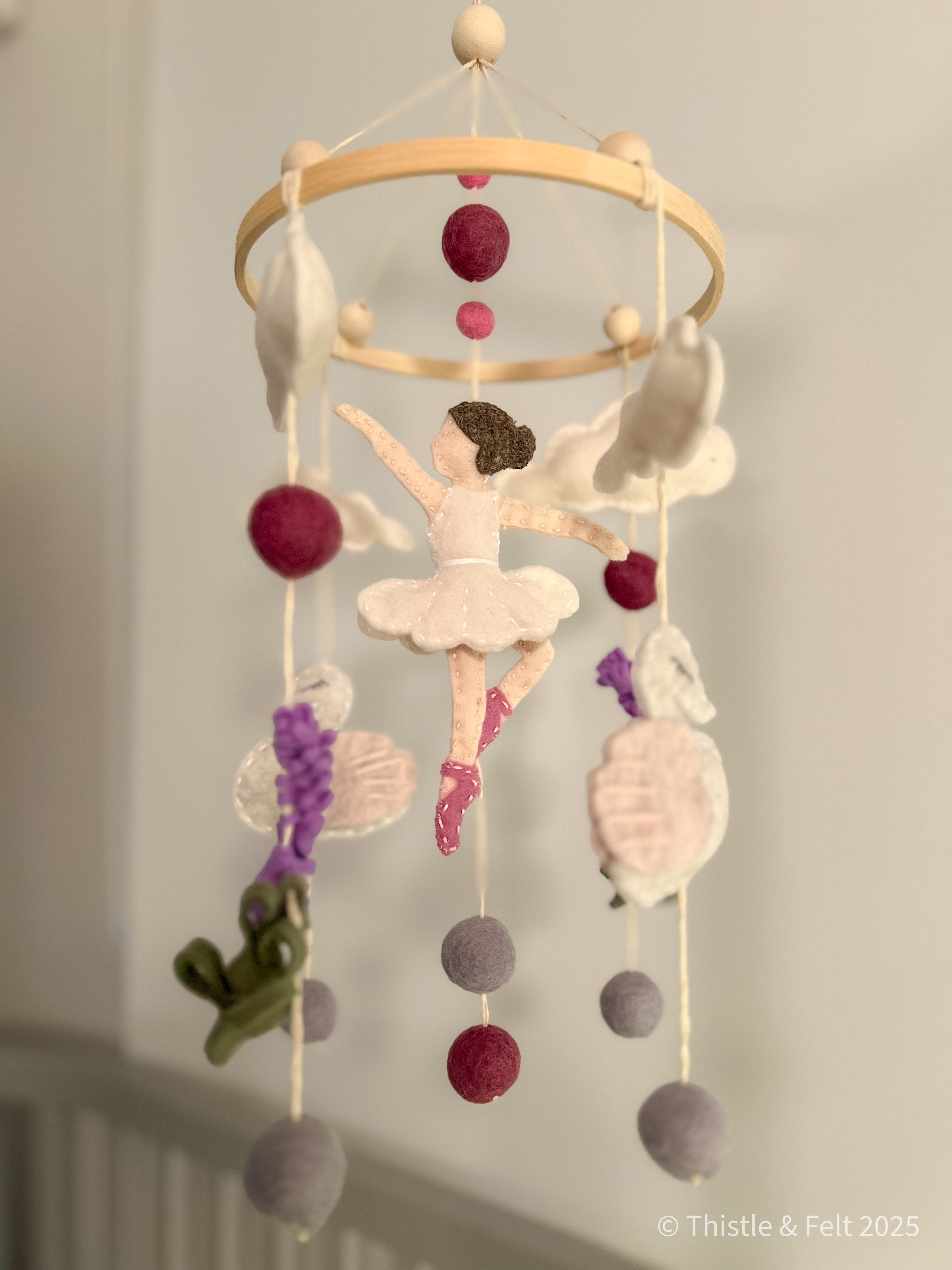 Handmade wool felt mobile featuring ballerina swans in soft pink and cream tones, inspired by classic fairytales.