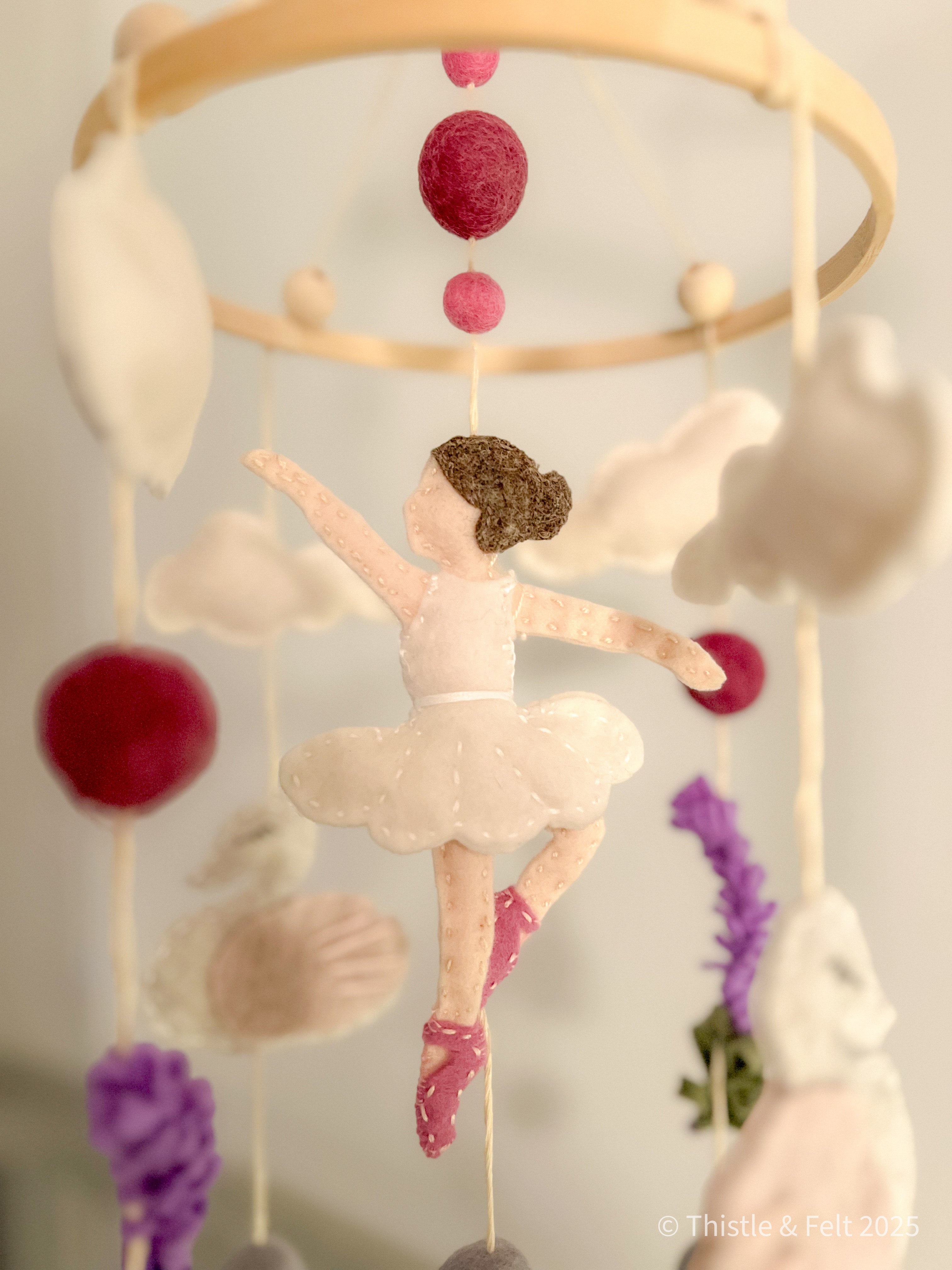 Handmade wool felt mobile featuring ballerina swans in soft pink and cream tones, inspired by classic fairytales.