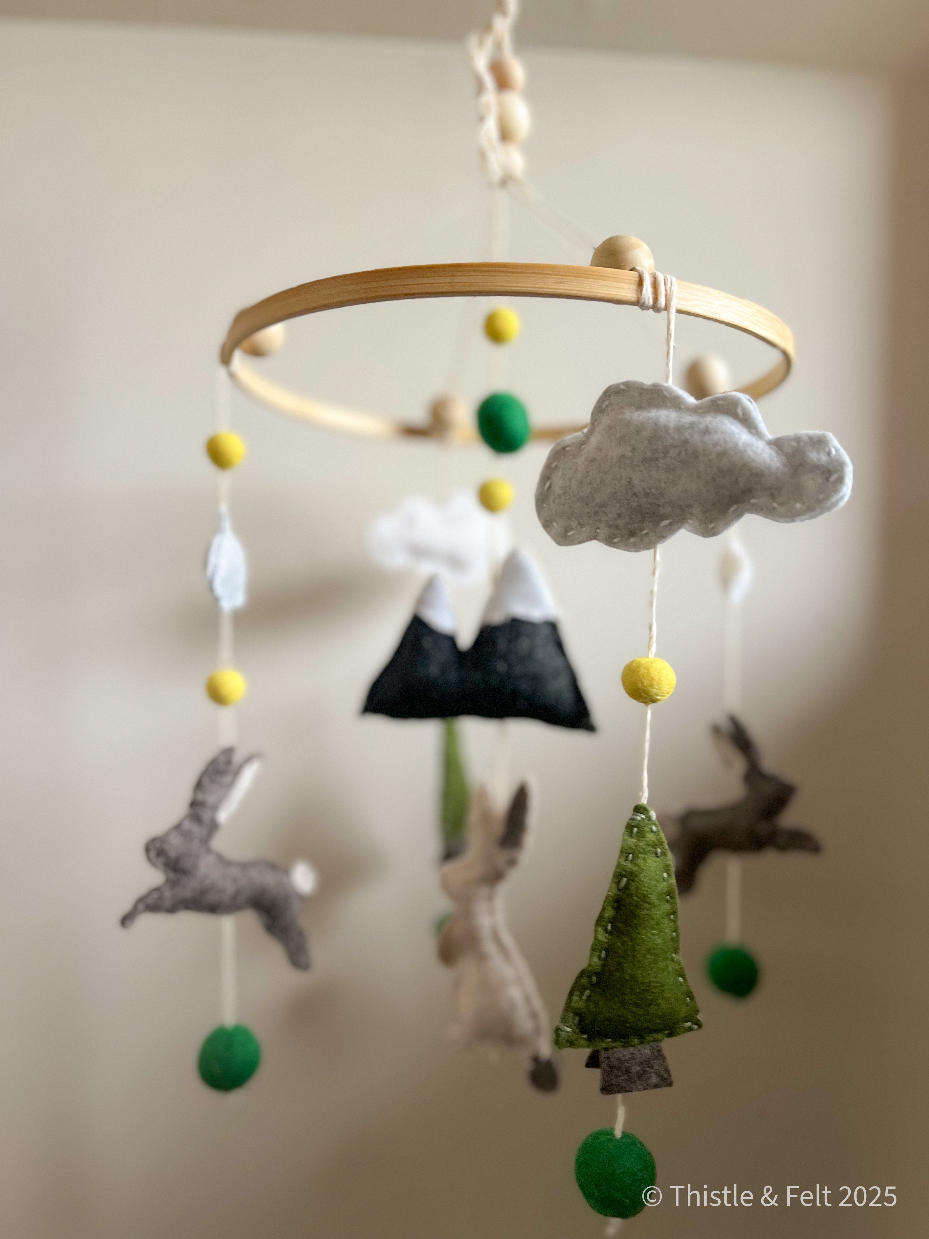 Where Bunnies Roam Mobile – handmade wool felt baby mobile featuring playful rabbits and natural tones, inspired by countryside meadows and crafted by Thistle & Felt.