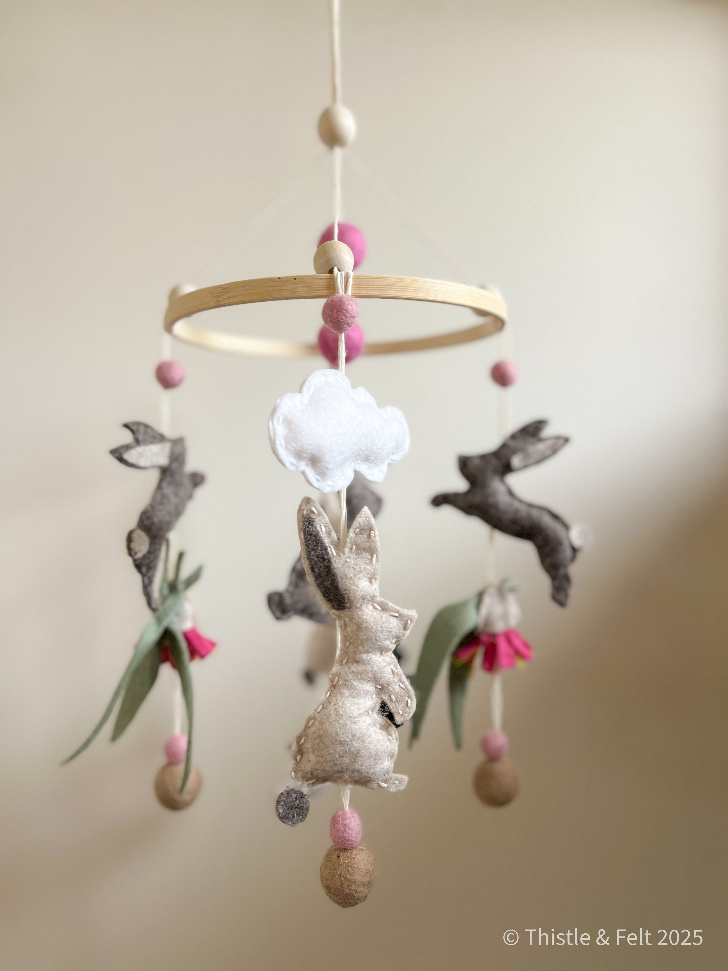 Handmade bunny felt nursery mobile with clouds by Thistle & Felt, perfect for natural nursery décor.