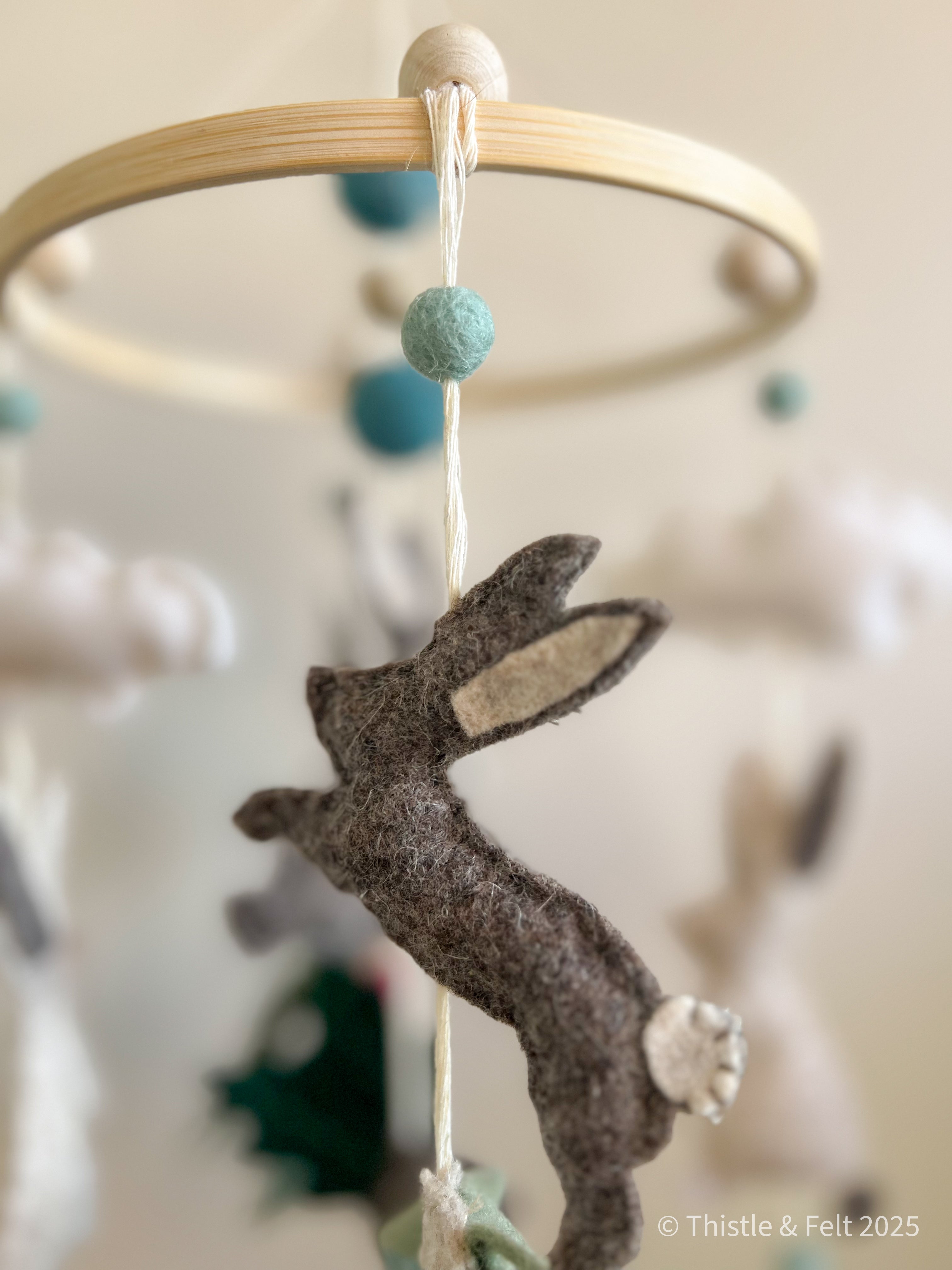 Handmade bunny felt nursery mobile with clouds by Thistle & Felt, perfect for natural nursery décor.